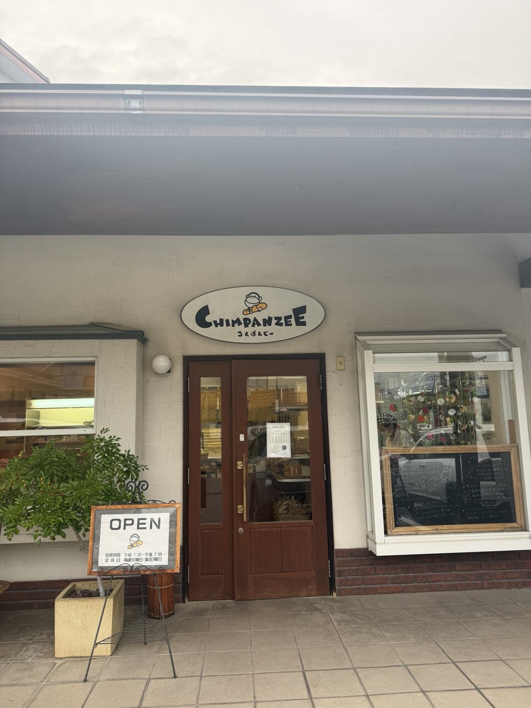 白い壁と茶色の扉の店先
