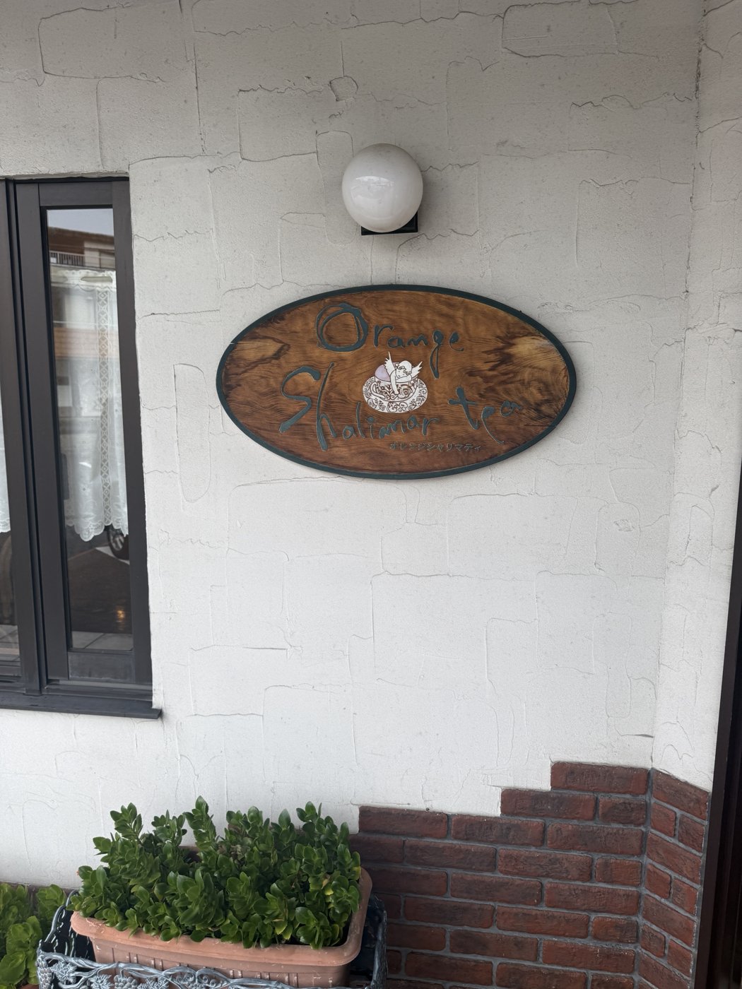 白い壁にかかった木の看板